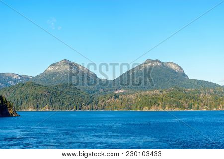 Fantastic view over ocean, snow mountain and rocks at Sechelt inlet in Vancouver, Canada.
