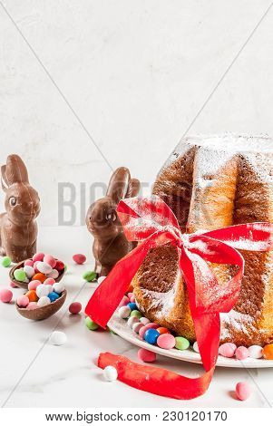 Traditional Italian Fruit Cake Panettone Pandoro With Festive Red Ribbon, Easter Rabbits And Sweet C