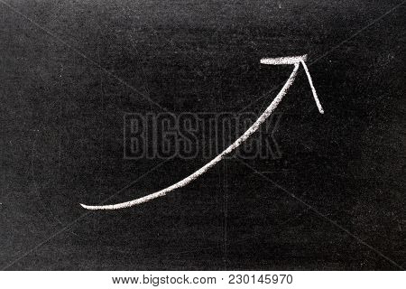 White Chalk Hand Drawing In Uptrend Arrow Shape On Blackboard Background