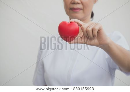 Senior Female Nurse Holding Red Heart Symbol In Her Hand; Isolate On White
