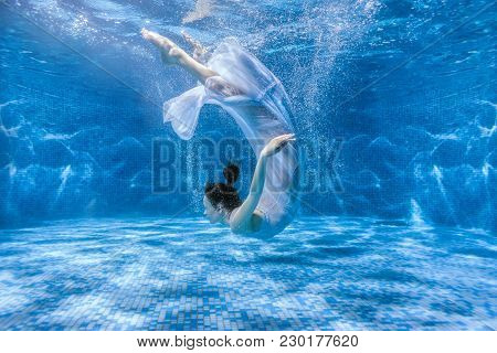Woman Dances Under The Water, She Is In The Pool.