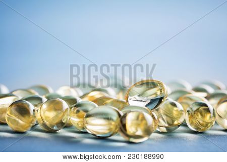 Bunch of vitamin D capsules laying on the table. Healthcare and supplementing concept.