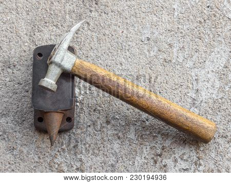 Old Small Hammer And Miniature Anvil With Concrete Background