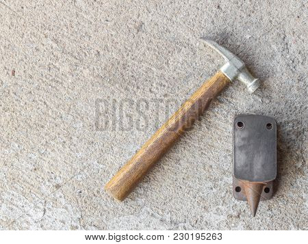 Old Small Hammer And Miniature Anvil With Concrete Background