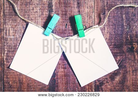 Paper Attach To Rope With Clothes Pins On Wooden Background