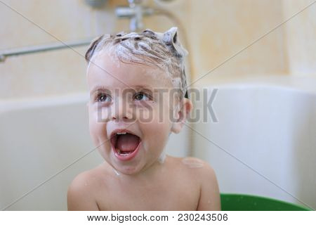 Little Girl Sitting In Bath And Laughing With Shampoo On Her Head