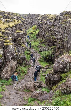 Thingvellir, Iceland - July 19, 2017: Tourists Walk Through The Almannagja Fault Line In The Mid-atl