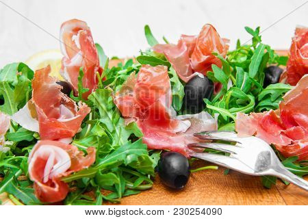 Chopping Board With Aragula And Raw Ham