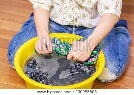 Woman Squeeze Wet Clothes In Room In Day