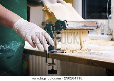 Process Of Production Of  Pasta. Fresh Pasta And Pasta Machine On Kitchen Table