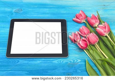 Tulip Flowers And Tablet Computer Device With Blank Screen On Blue Wooden Table Board Background Wit