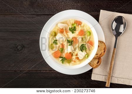 An Overhead Photo Of A Plate Of Chicken, Vegetables, And Noodles Soup, Shot From Above On A Dark Rus