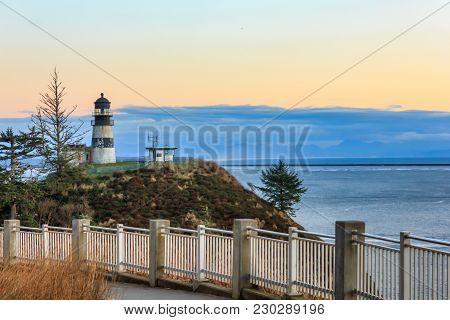 Railing In Front Of Light House Over Cliffs And Ocean