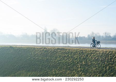 Capelle Aan Den Ijsel, Rotterdam, Netherlands - March 3rd, 2018 : Young Woman Cycling By The Ijsel C