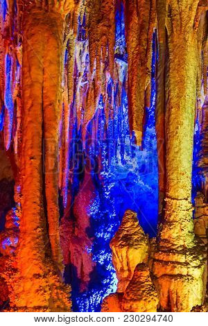 Cave Yellow And Blue Illuminated Flowstones, Stalactites And Stalagmites
