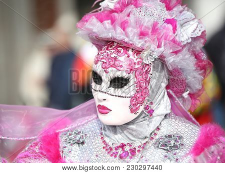 Venice, Italy - February 5, 2018: Woman In Costume With Pink And White Mask In Saint Mark Square