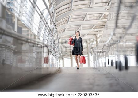 Attractive And Exusive Business Woman Wearing Modern Sunglass With Lot Of Red Shopping Bags. Happy A