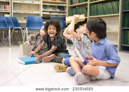 Happy Kids Reading On The Floor, Education Lifestlye In The Library. Young People Explore Lifestlye 