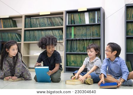 Happy Kids Reading On The Floor, Education Lifestlye In The Library. Young People Explore Lifestlye 