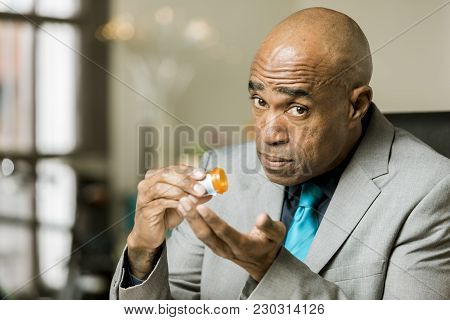 Man Holding An Opioid Pill And Bottle
