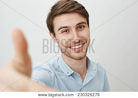 Here, Let Me Lend You Hand. Portrait Of Charming Friendly Caucasian Man Pulling Hand Towards Camera 