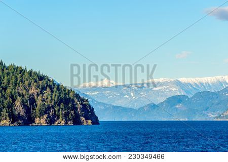 Fantastic view over ocean, snow mountain and rocks at Sechelt inlet in Vancouver, Canada.