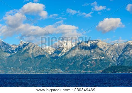 Fantastic view over ocean, snow mountain and rocks at Sechelt inlet in Vancouver, Canada.