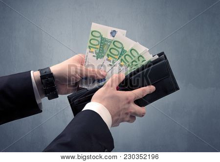 Businessman's hand in suit takes out eruo from his wallet