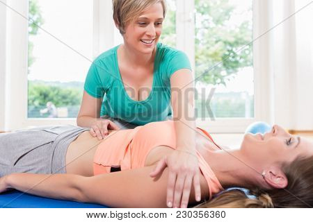 Woman in postnatal gymnastics course gets pregnancy recovery massage