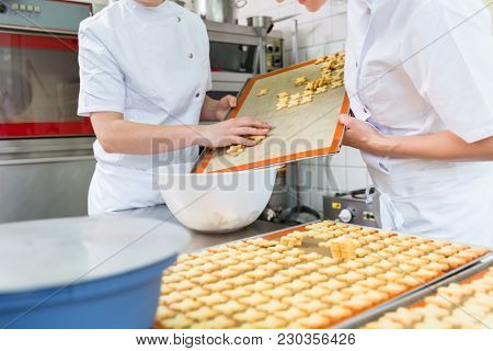 Cookies being baked in pastry bakery being slid off sheet
