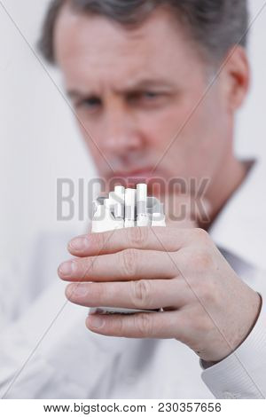 background image of serious businessman holding an open pack of cigarettes