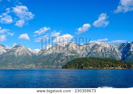Fantastic view over ocean, snow mountain and rocks at Sechelt inlet in Vancouver, Canada.