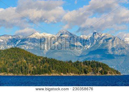 Fantastic view over ocean, snow mountain and rocks at Sechelt inlet in Vancouver, Canada.