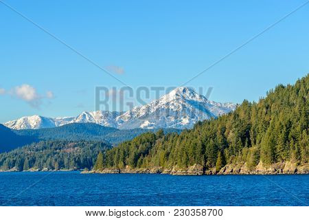 Fantastic view over ocean, snow mountain and rocks at Sechelt inlet in Vancouver, Canada.