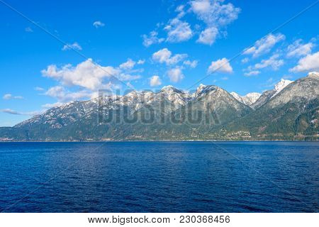 Fantastic view over ocean, snow mountain and rocks at Sechelt inlet in Vancouver, Canada.