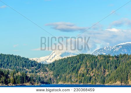 Fantastic view over ocean, snow mountain and rocks at Sechelt inlet in Vancouver, Canada.