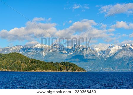Fantastic view over ocean, snow mountain and rocks at Sechelt inlet in Vancouver, Canada.