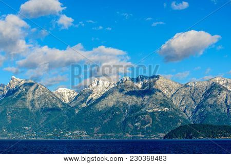 Fantastic view over ocean, snow mountain and rocks at Sechelt inlet in Vancouver, Canada.
