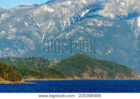 Fantastic view over ocean, snow mountain and rocks at Sechelt inlet in Vancouver, Canada.