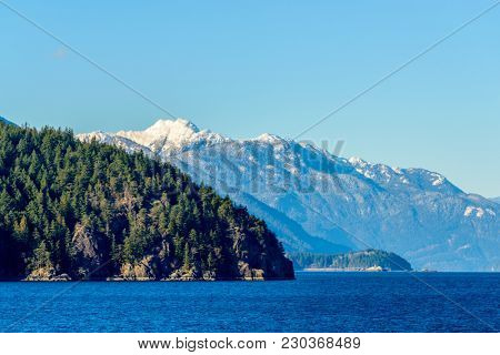 Fantastic view over ocean, snow mountain and rocks at Sechelt inlet in Vancouver, Canada.