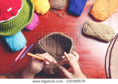 Close Up Hand Of Old Woman Knitting Woolhate On Wooden Table Background