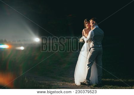 The Bride And Groom At Sunset On A Dark Background