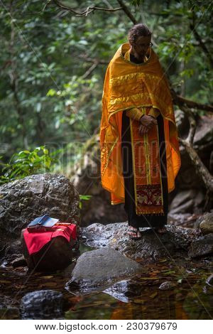 KOH CHANG, THAILAND - MAR 9, 2018: Orthodox priest during sacrament of spiritual birth - Baptism. There are currently 10 Orthodox parishes in Thailand, Orthodoxy is practiced by 0.002% of population.