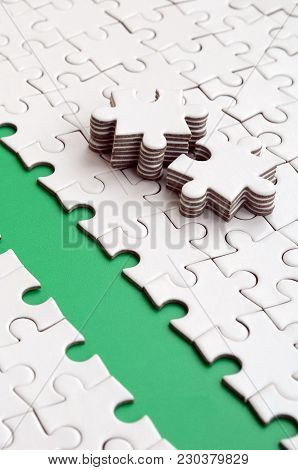 The Green Path Is Laid On The Platform Of A White Folded Jigsaw Puzzle. The Missing Elements Of The 