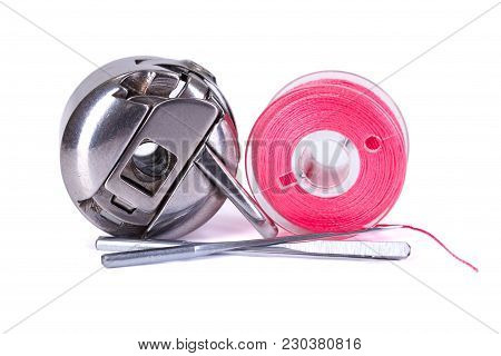 Bobbin Case, Plastic Bobbin And Sewing Machine Needles On White Background
