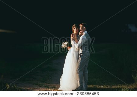 The Bride And Groom At Sunset On A Dark Background
