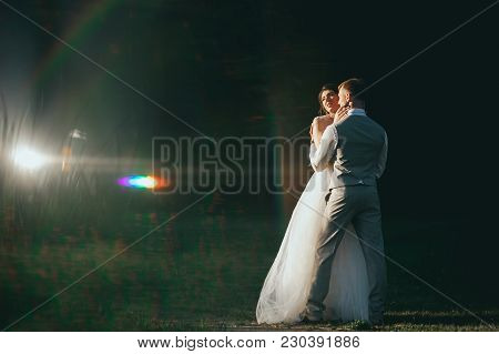 The Bride And Groom At Sunset On A Dark Background