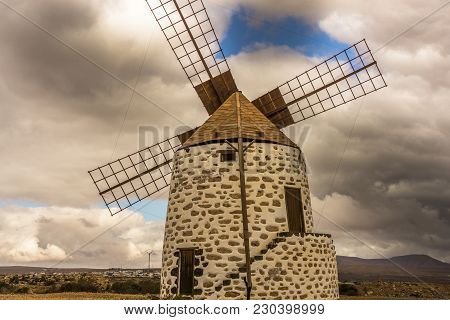 Spanish Windmill Made Of Stone With Blue Sky And Dark Clouds