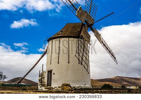 Spanish Windmill Made Of Stone With Blue Sky And Dark Clouds