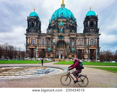Berlin, Germany - December 12, 2017: Man Riding A Bicycle At Berliner Dom Cathedral In Berlin On Mit